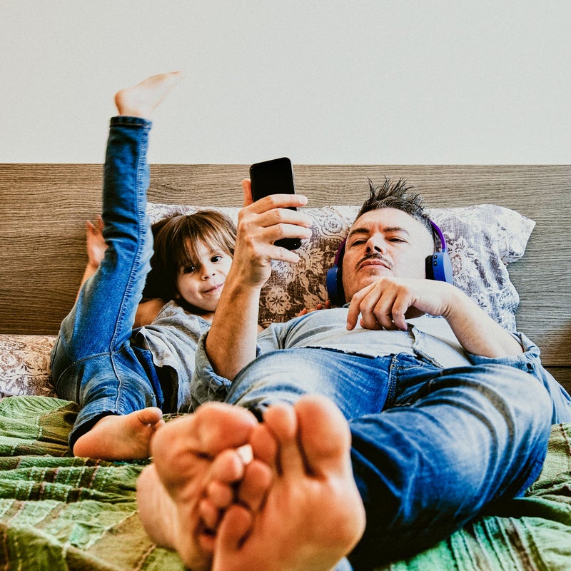 padre e hijo tumbados en la cama escuchando música