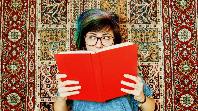 Mujer leyendo un libro rojo