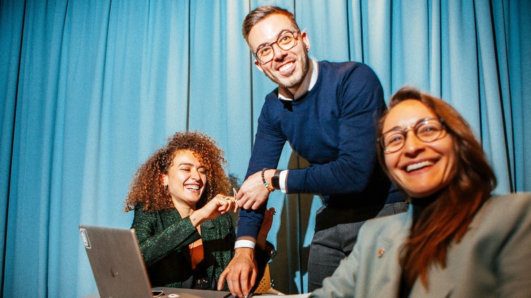 Personas sonriendo frente a un ordenador
