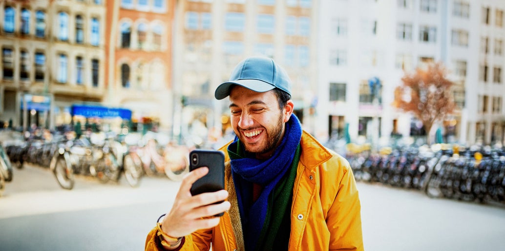 Hombre sonriendo y mirando el móvil