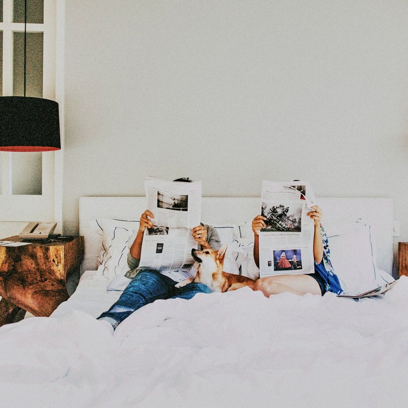 pareja leyendo el periódico en la cama