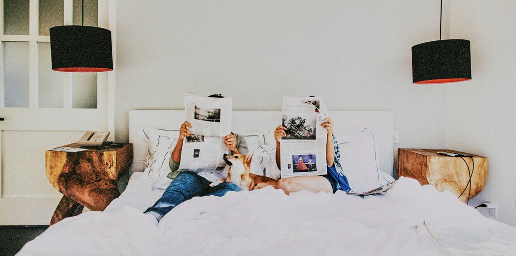 pareja leyendo el periódico en la cama