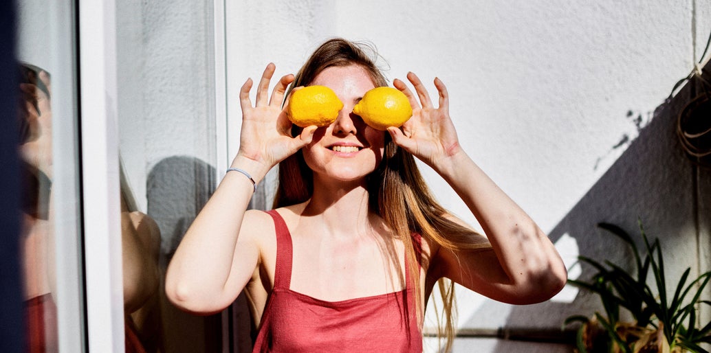 chica poniéndose dos limones delante de los ojos
