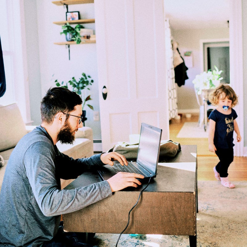 padre trabajando en casa con su hija