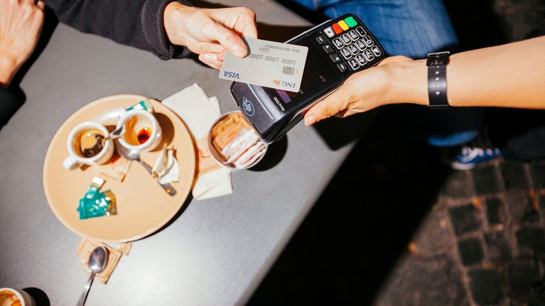 Persona pagando con tarjeta de crédito en cafeteria
