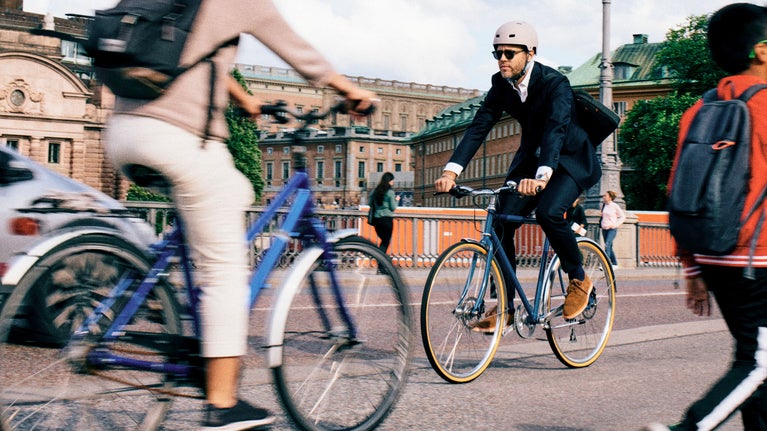 Hombre con casco montando en bicicleta en la ciudad
