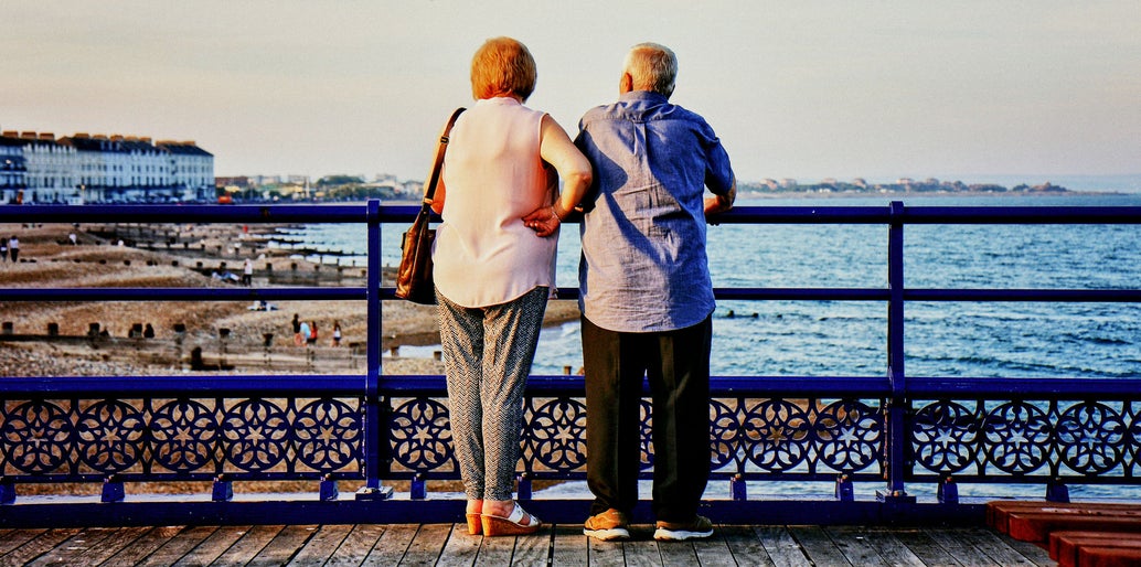 Pareja mayor en un banco viendo atardecer