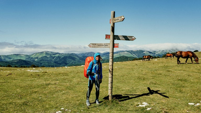 Mujer sonriente con mochila en la naturaleza