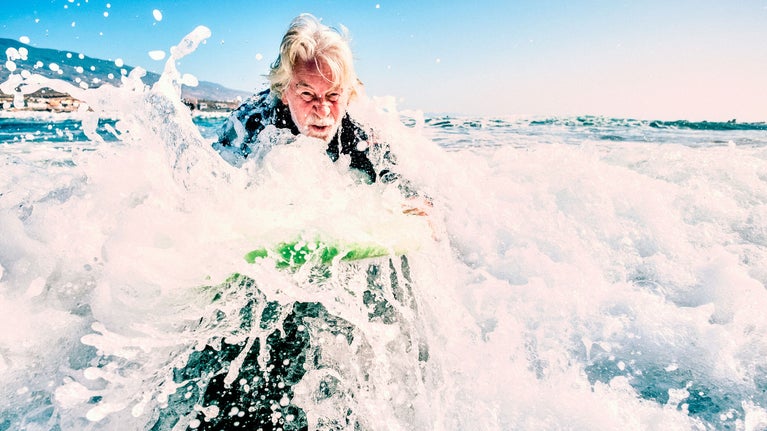 Hombre mayor haciendo surf en su jubilación
