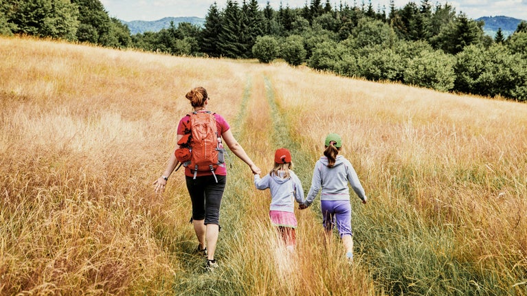 Madre caminando con niñas por el campo