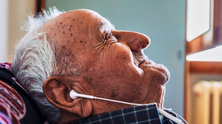 Hombre mayor escuchando musica con cascos