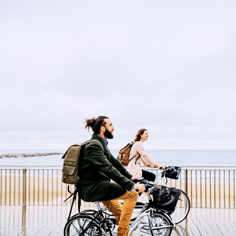 Un hombre y una mujer en bicicleta mirando el mar