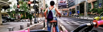 Mujer manejando bicicleta por la ciudad