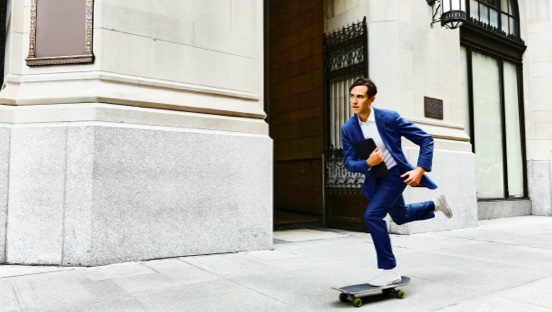 Chico trajeado en patinete