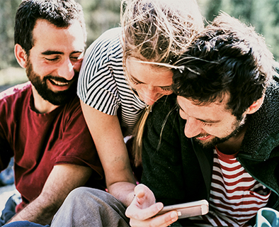 Amigos mirando el móvil sonriendo