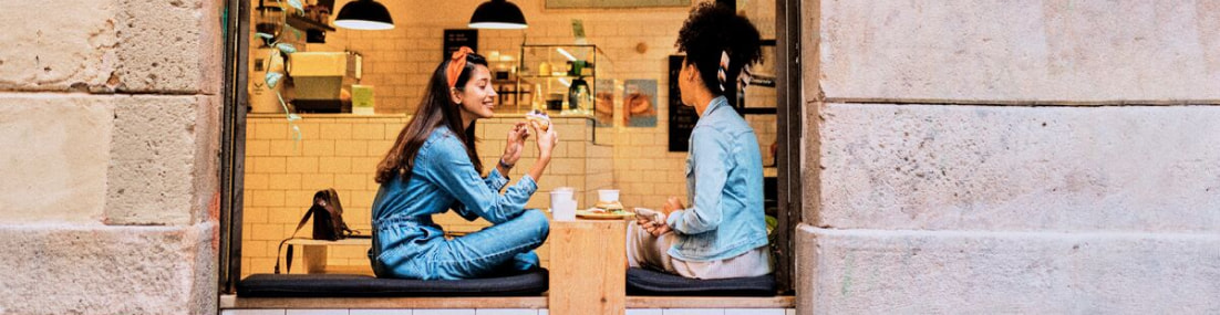 Dos chicas en una cafetería desayunando