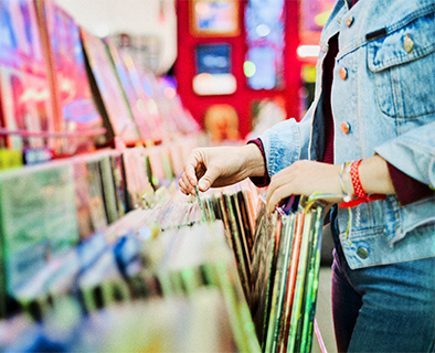 Manos de mujer en tienda eligiendo vinilos